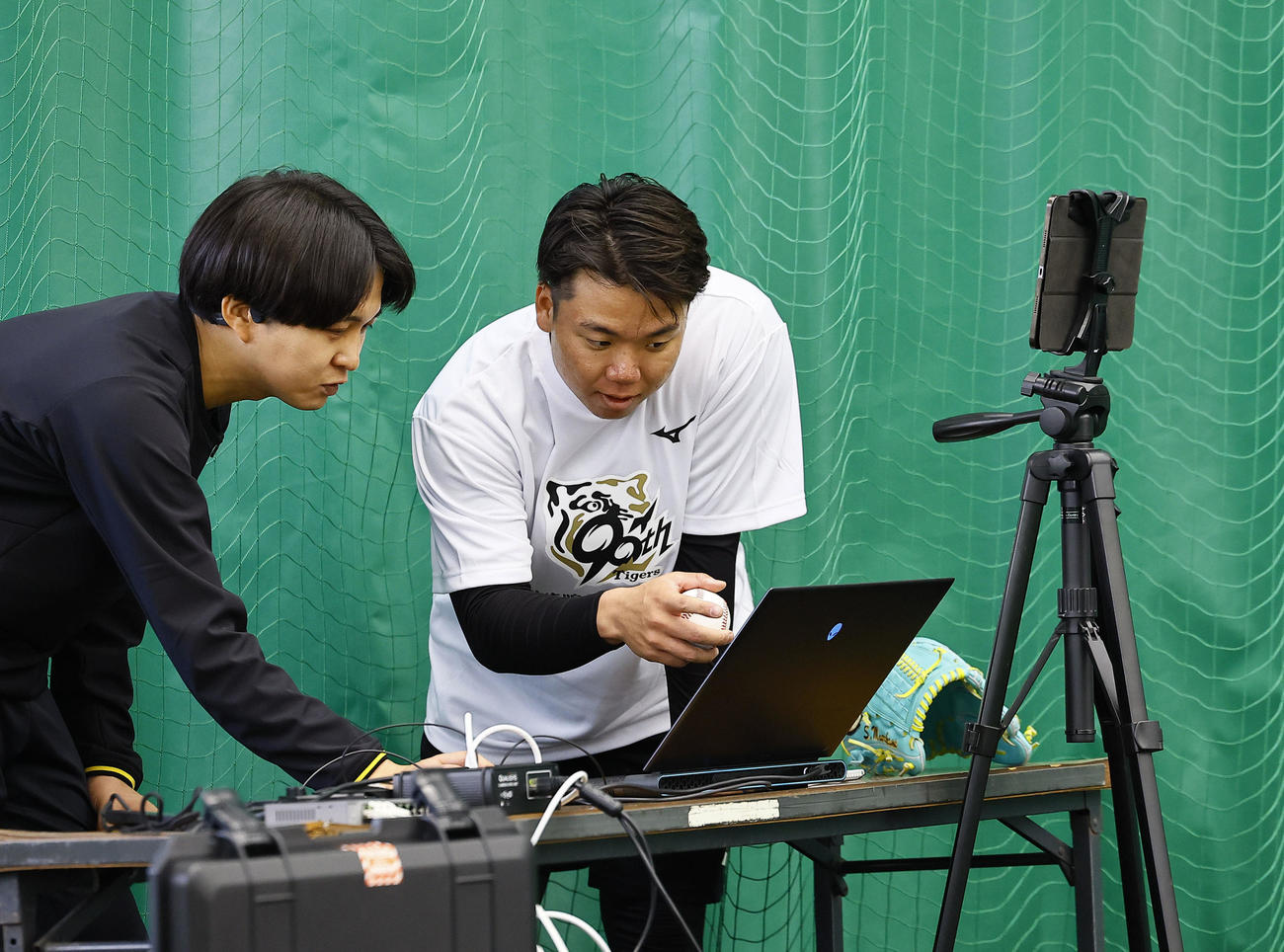 合同自主トレで、ブルペン投球を終え動作解析のデータを見る阪神村上（撮影・藤尾明華）