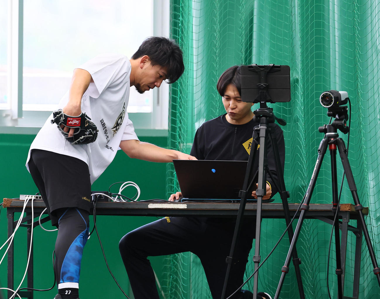 合同自主トレのブルペンで、データを確認する阪神伊藤将（撮影・藤尾明華）