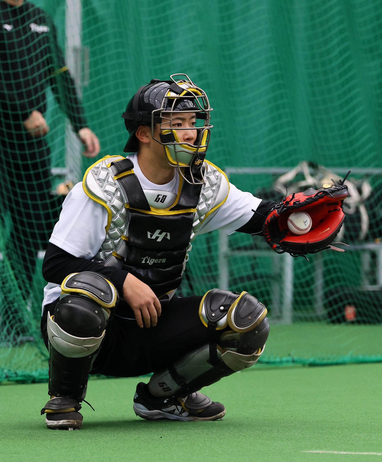 合同自主トレのブルペンで、伊原の球を受ける阪神中川（撮影・藤尾明華）