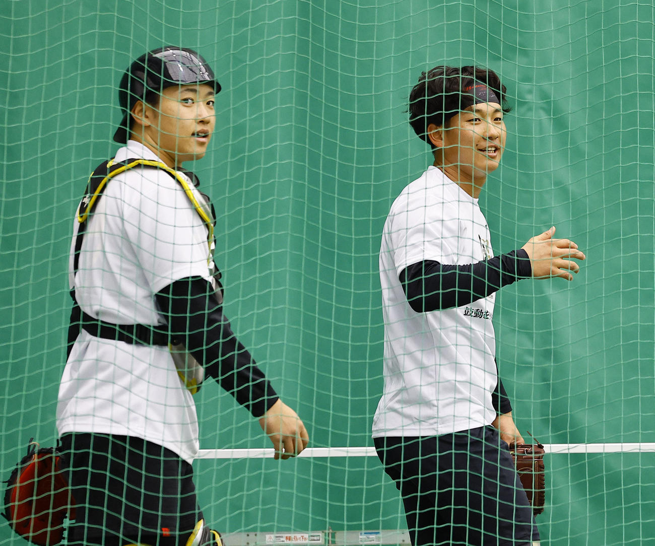 合同自主トレのブルペンで、投球練習を終え中川（左）と話しをする阪神伊原（撮影・藤尾明華）
