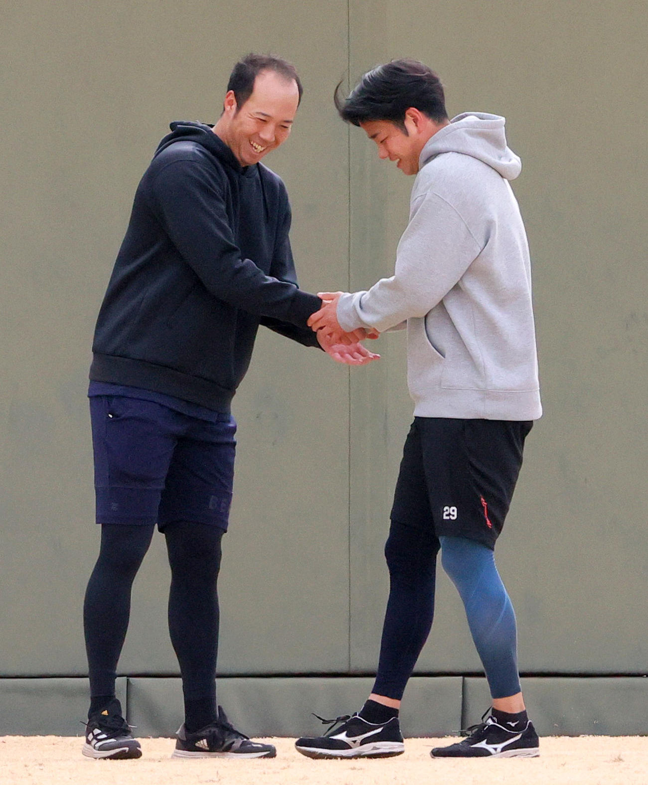 MLBに挑戦の青柳（左）は高橋と鳴尾浜球場で握手をかわし引き揚げる（撮影・上山淳一）