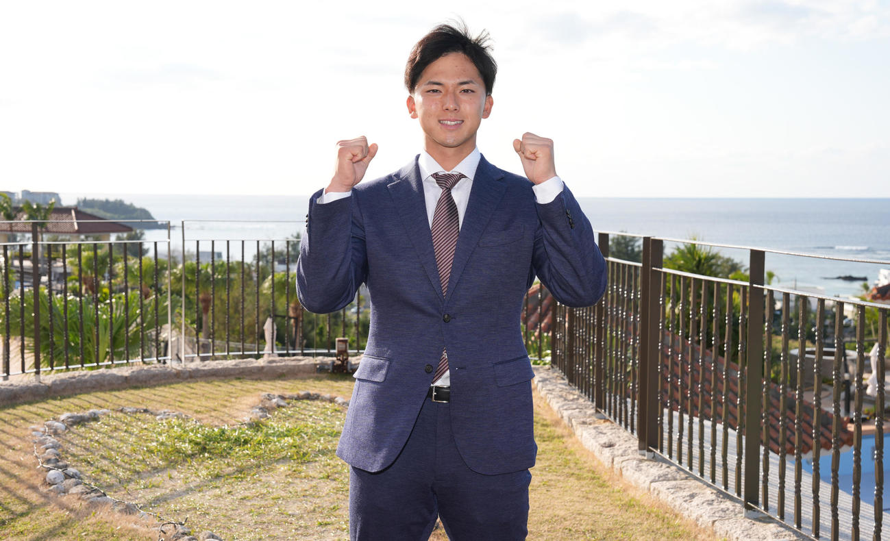 沖縄入りし、海をバックにガッツポーズする楽天宗山（撮影・鈴木みどり）