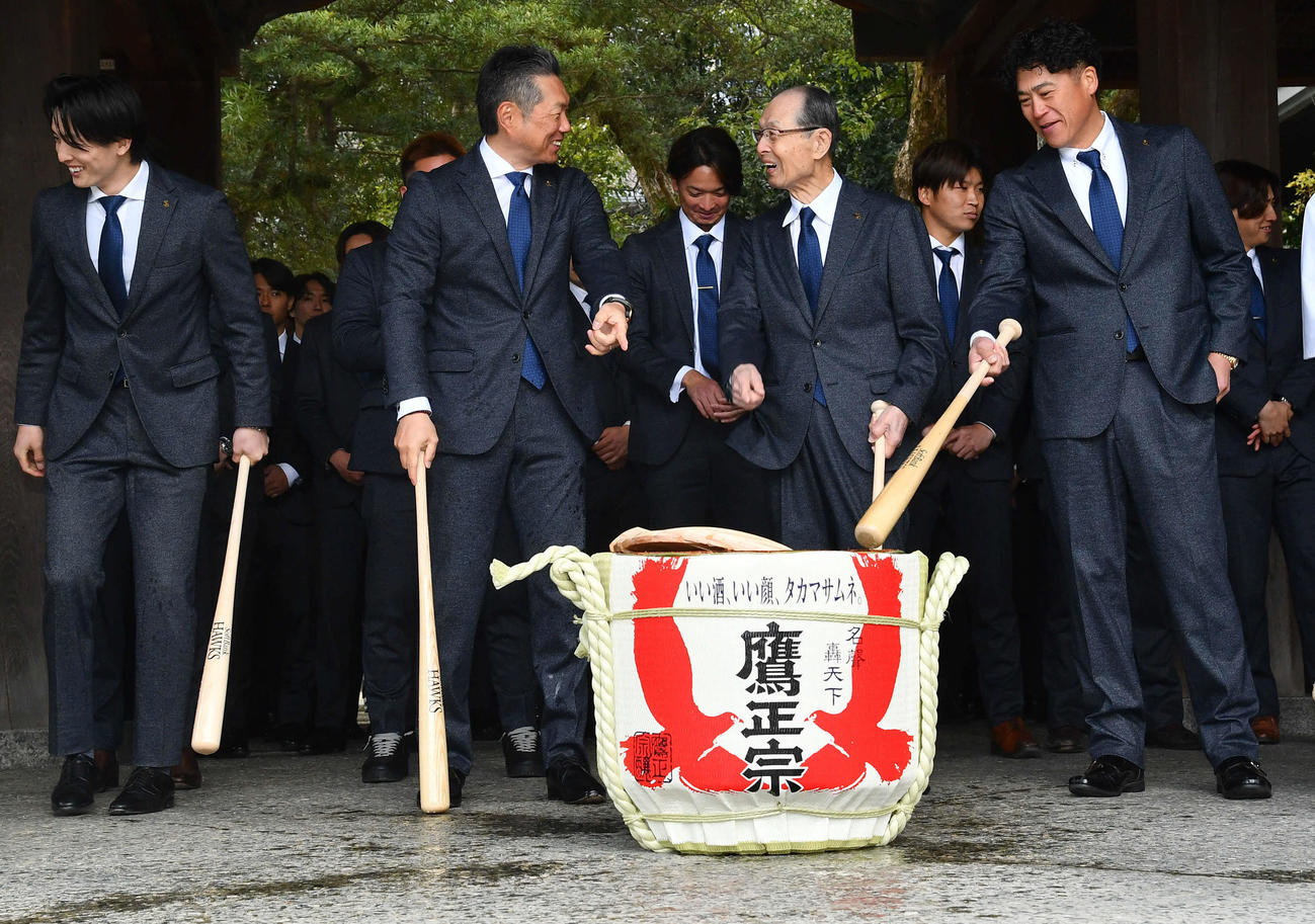 必勝祈願後の鏡開きで酒が勢いよく飛び出し笑顔を見せる、左からソフトバンク周東、小久保監督、王球団会長、城島CBO（撮影・岩下翔太）