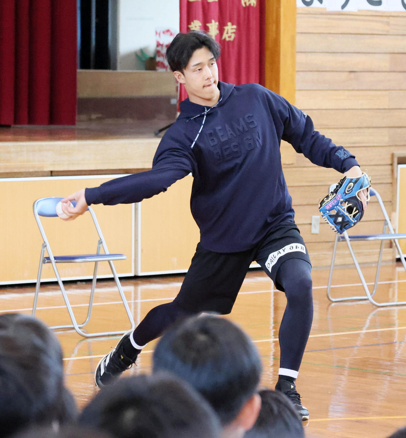 うるま市内の小学校を訪問し子供たちの前でサイドスローを見せる小幡（撮影・加藤哉）