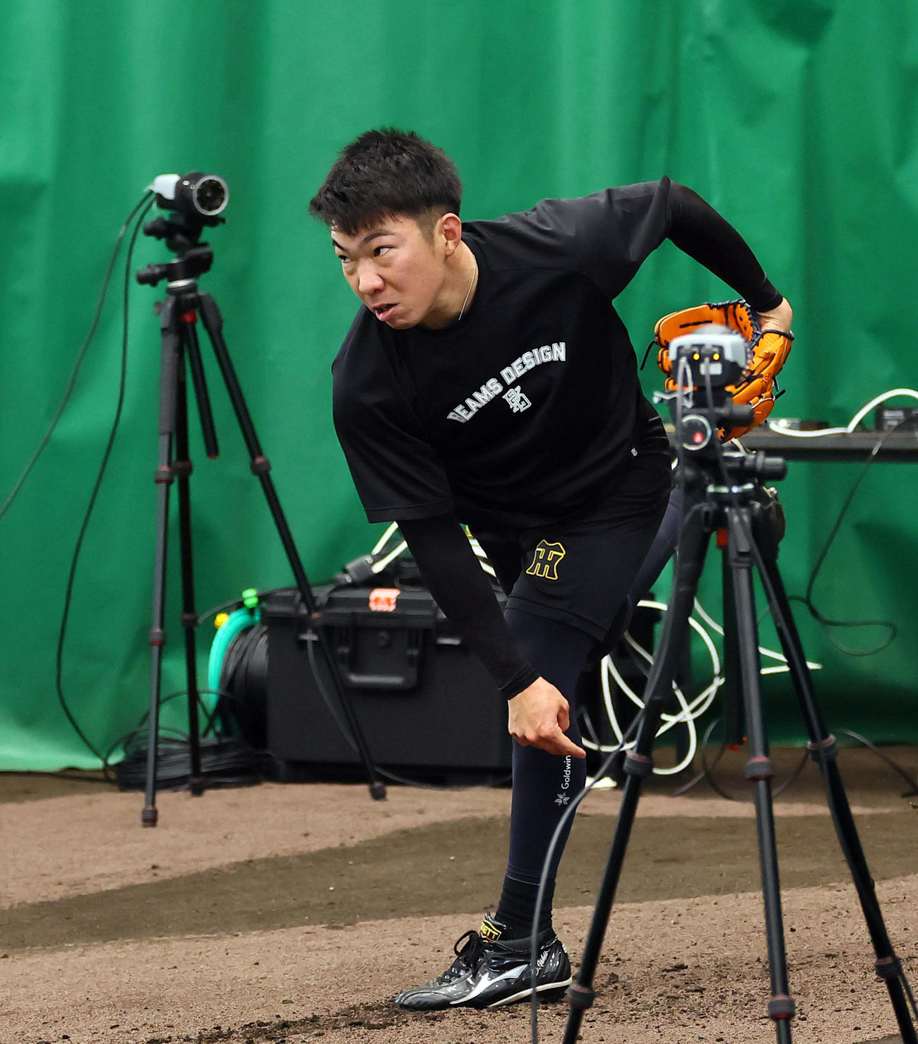 合同自主トレで、動作解析のカメラに囲まれ投球練習をする阪神石井（撮影・藤尾明華）