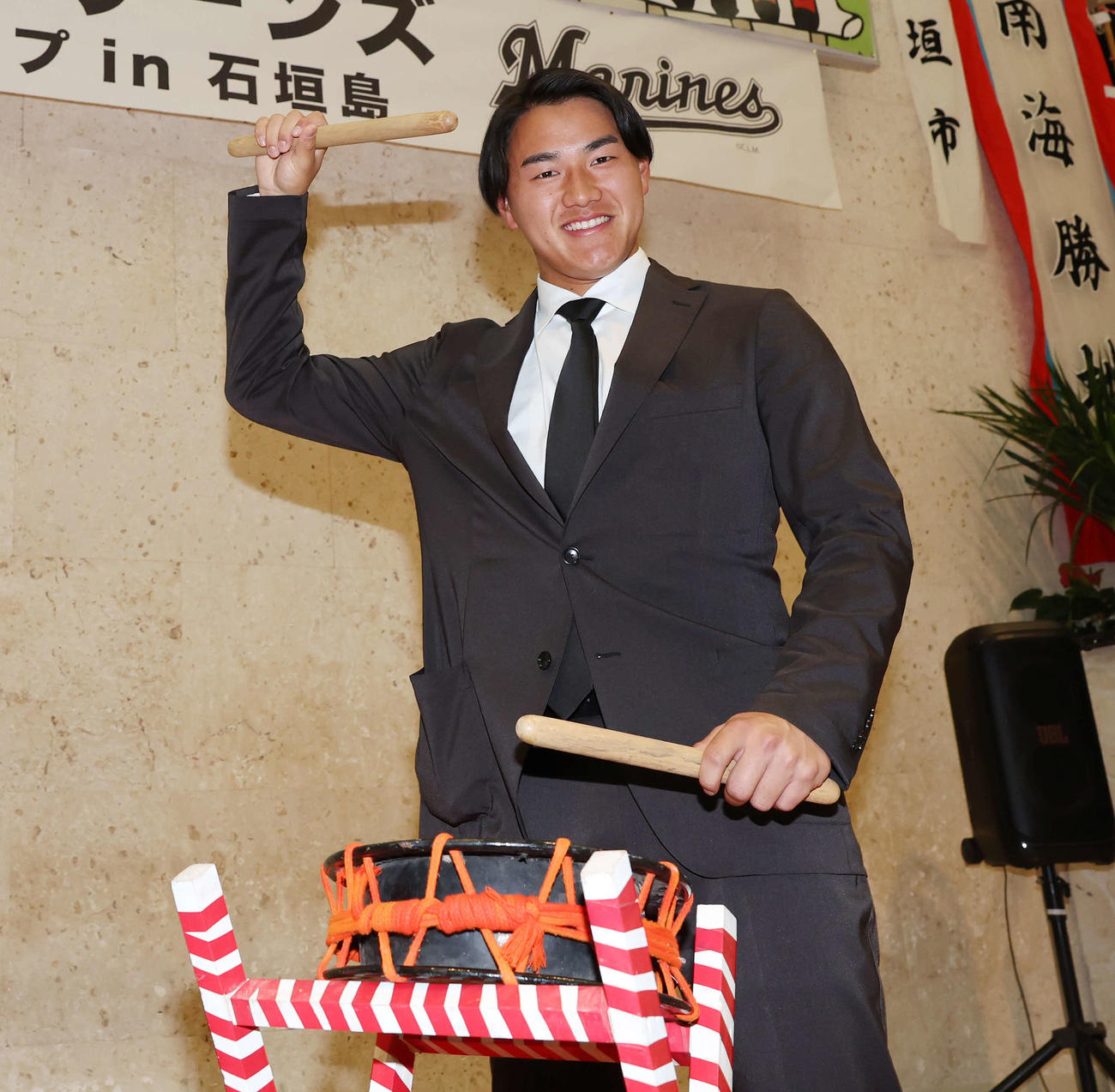 石垣空港に到着したロッテ西川は笑顔で太鼓をたたく（撮影・宮地輝）
