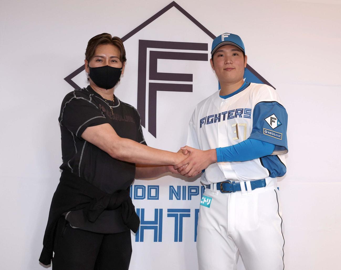 記者会見で握手する日本ハム新庄監督（左）と新入団の古林睿煬（撮影・黒川智章）