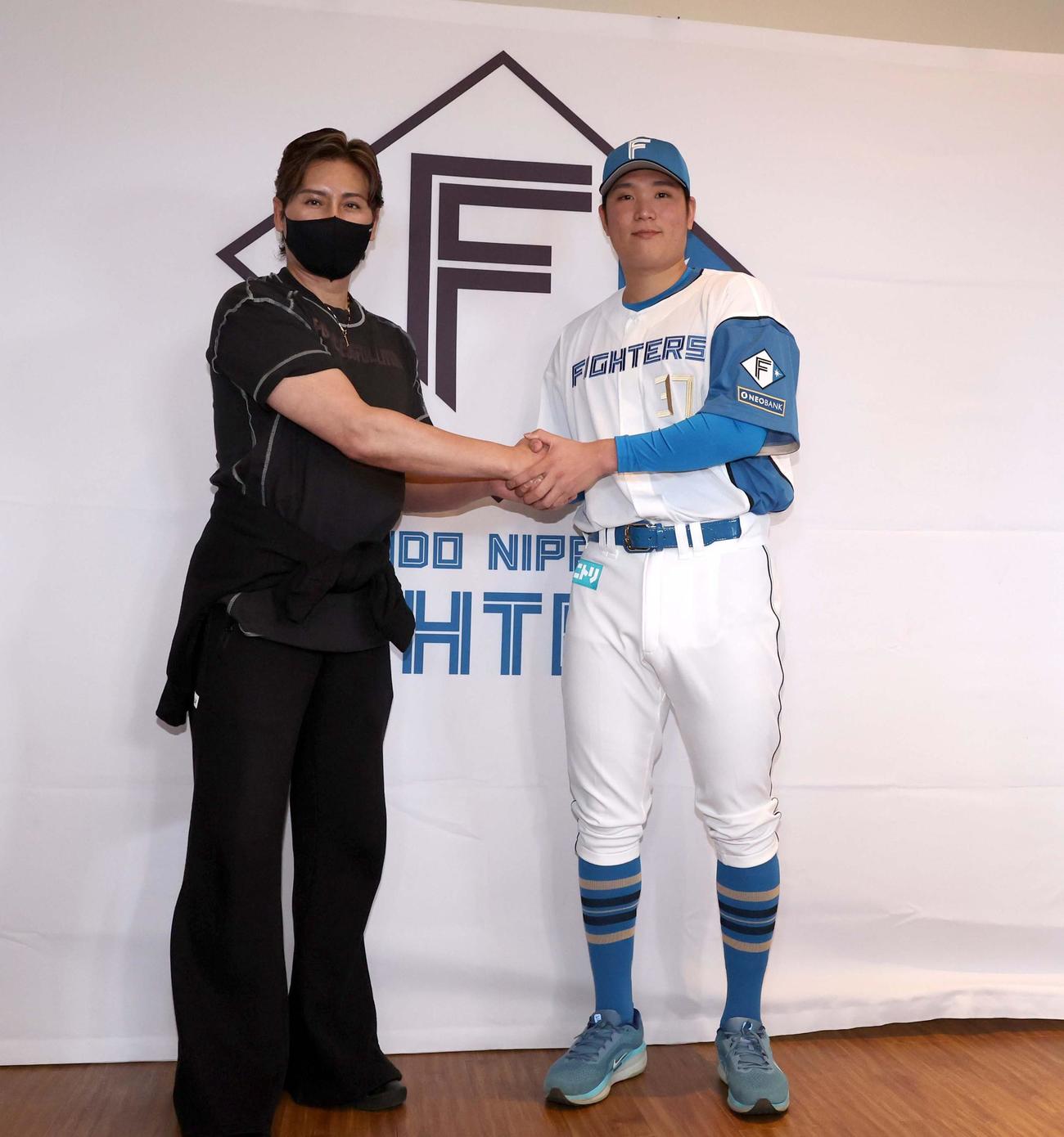 記者会見で握手する日本ハム新庄監督（左）と新入団の古林睿煬（撮影・黒川智章）