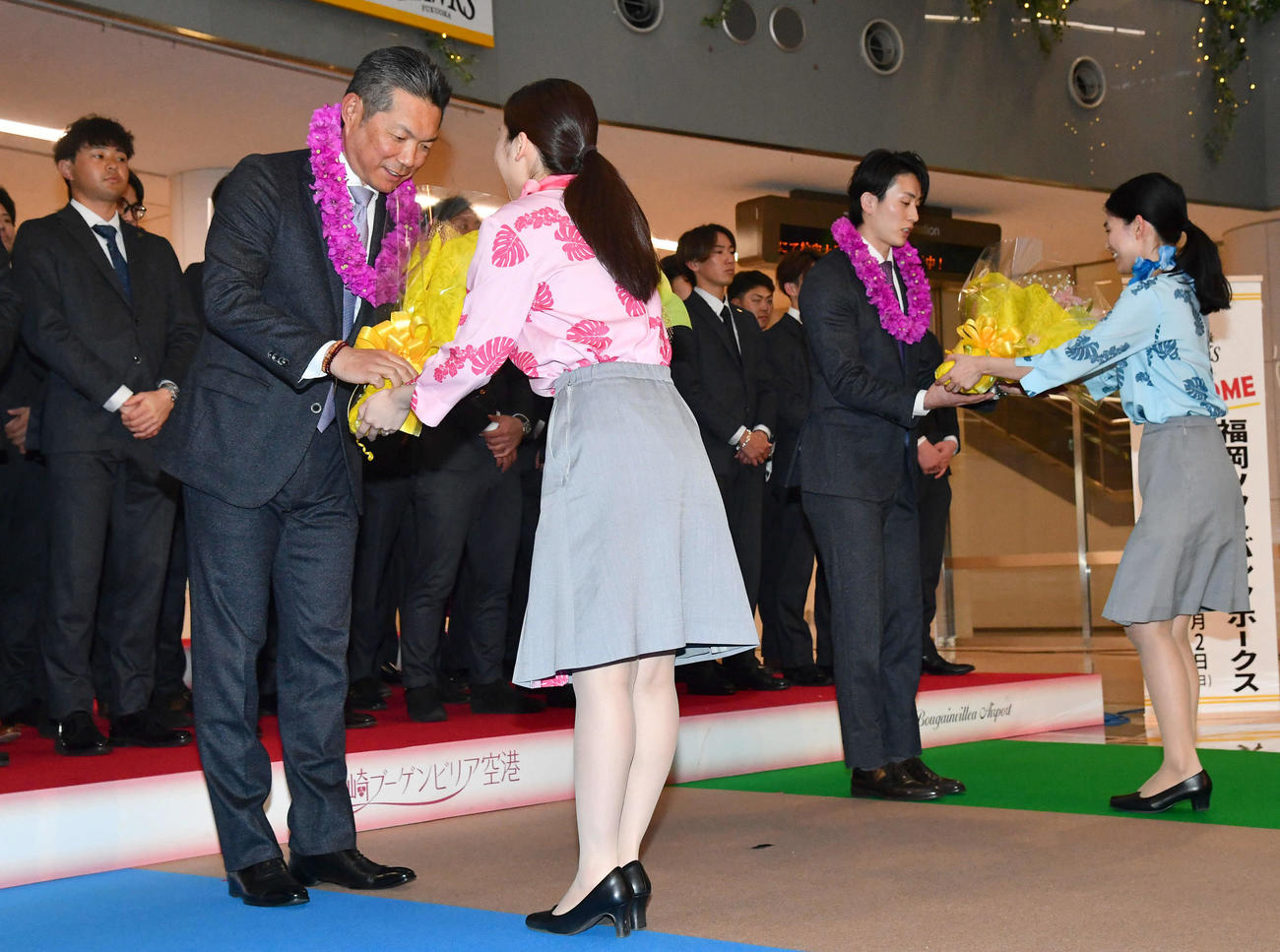 宮崎空港に到着し、歓迎セレモニーで花束を贈呈されるソフトバンク小久保監督（左）と周東（撮影・岩下翔太）