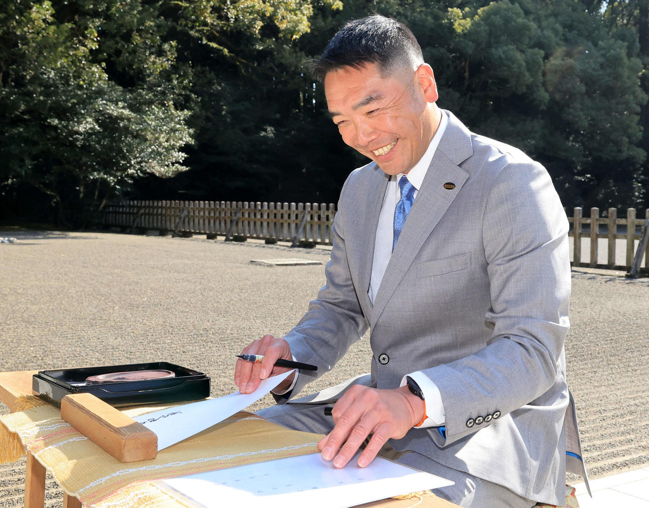 宮崎神宮に参拝し、奉納する書面を書きながら笑顔の巨人阿部監督（撮影・浅見桂子）