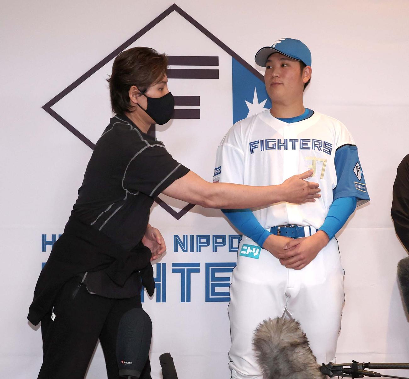 記者会見で新入団の古林睿煬の脇腹を触る日本ハム新庄監督（撮影・黒川智章）