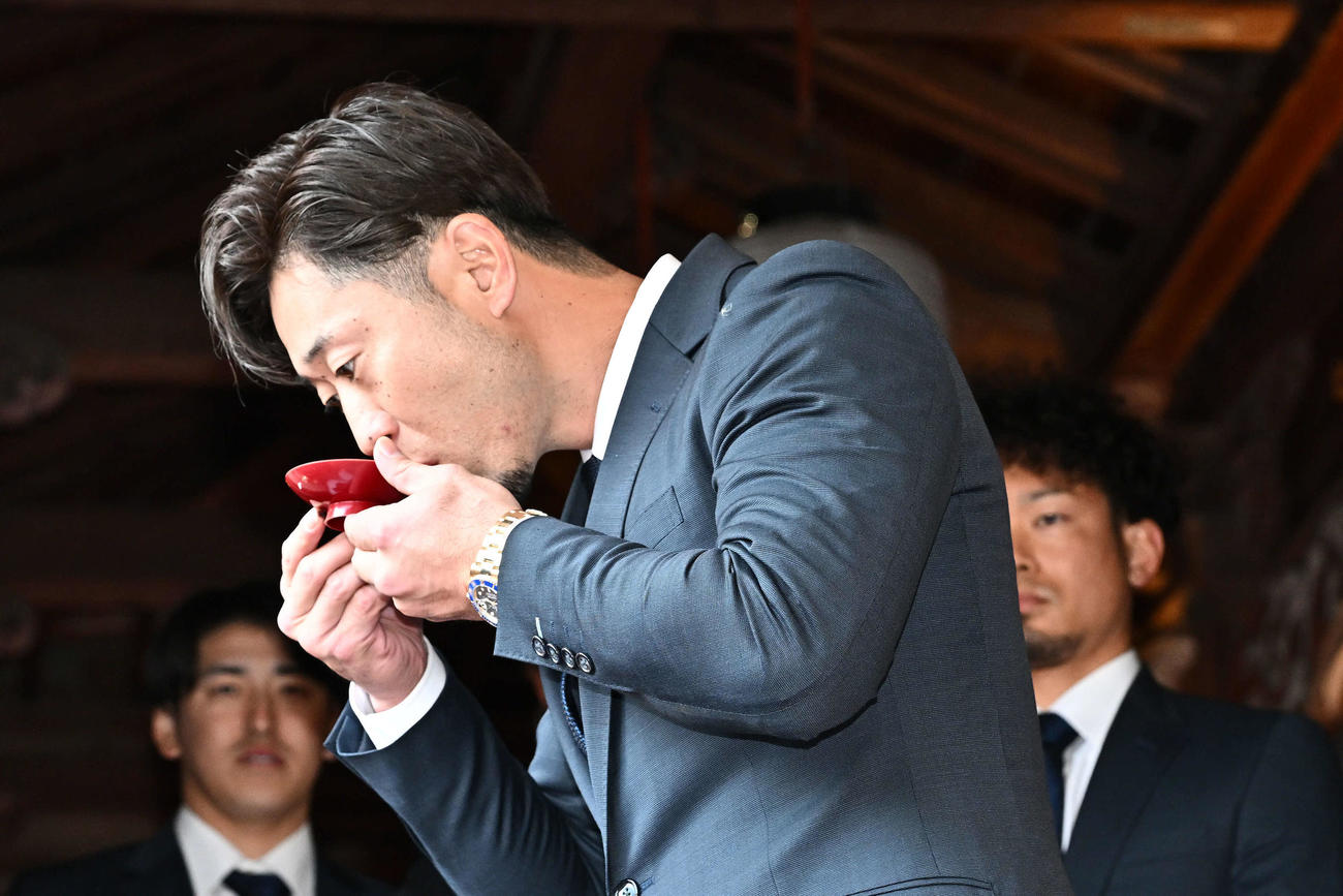 榎原神社で無事息災祈願を終えお神酒を飲む西武外崎（撮影・滝沢徹郎）