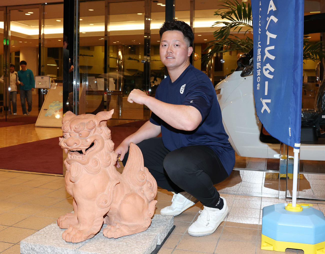 シーサーを前にデスターシャのポーズを決めるDeNA牧（撮影・鈴木正人）