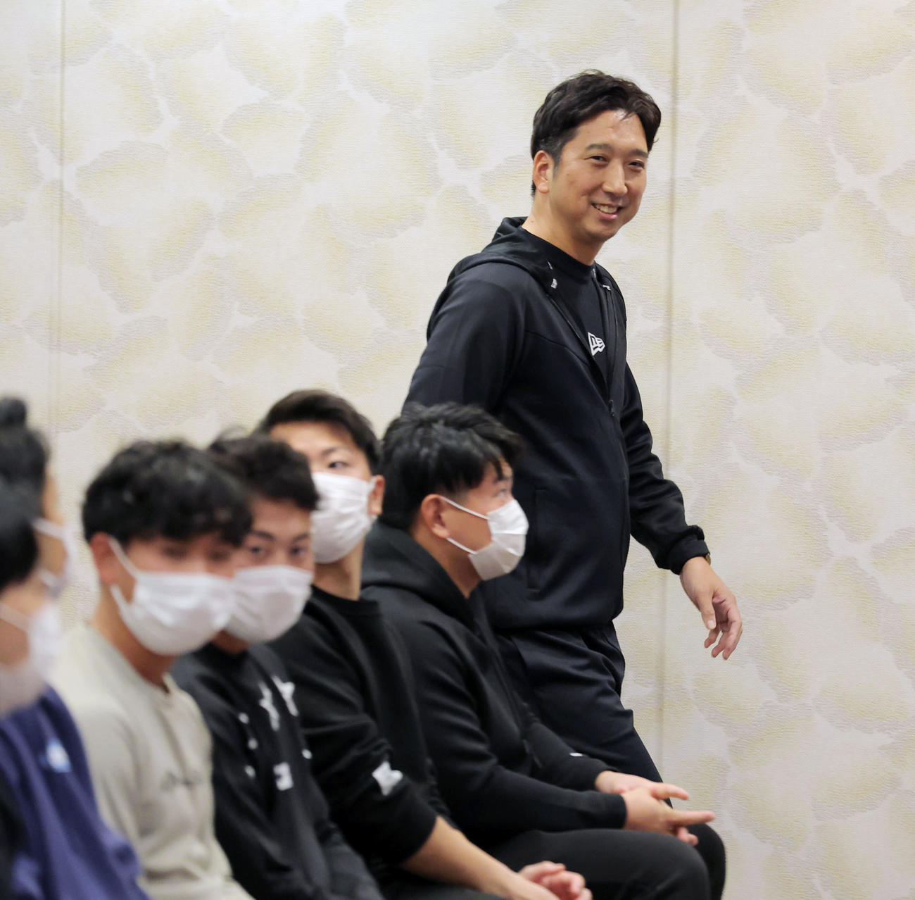 キャンプ前日のミーティングに出席するナインと明るい表情で入場する藤川監督