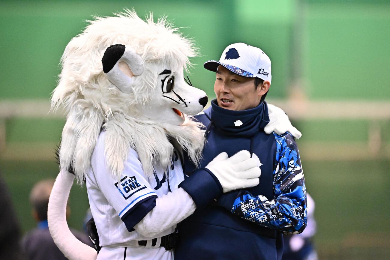 練習前にレオとじゃれ合う西武源田（撮影・滝沢徹郎）
