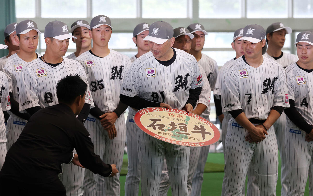 キャンプインセレモニーで贈呈された石垣牛を渡すのを惜しむロッテ吉井監督（撮影・宮地輝）