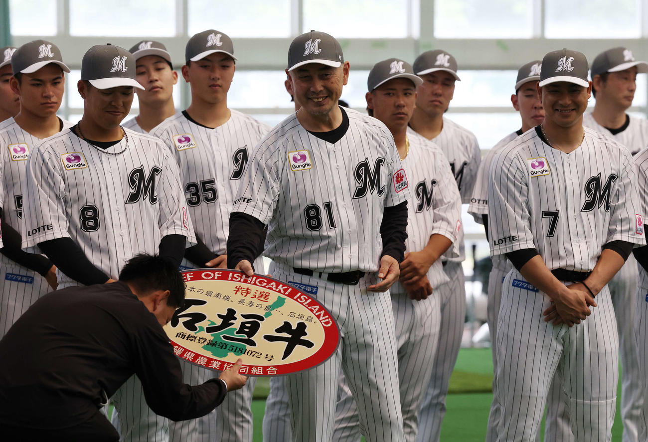 キャンプインセレモニーで贈呈された石垣牛を惜しみながら渡すロッテ吉井監督（撮影・宮地輝）