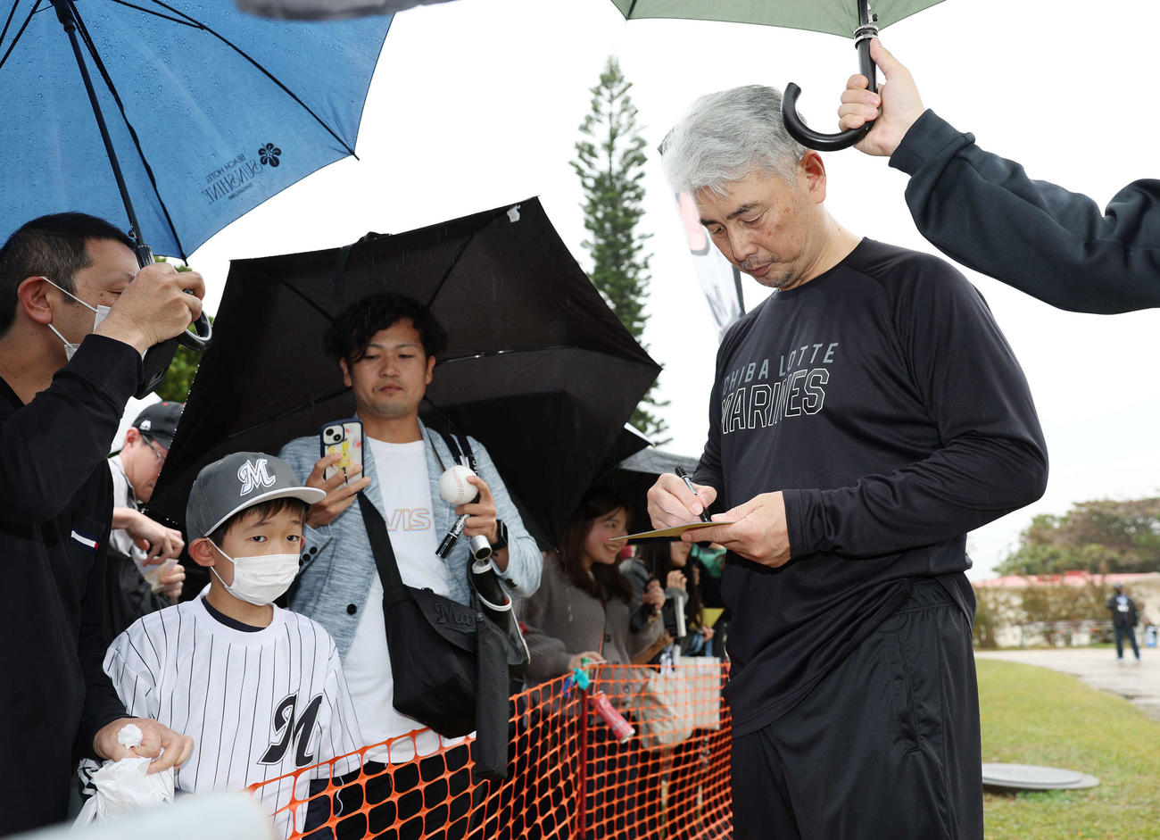 雨が降る中ファンにサインをするロッテ吉井監督（撮影・宮地輝）