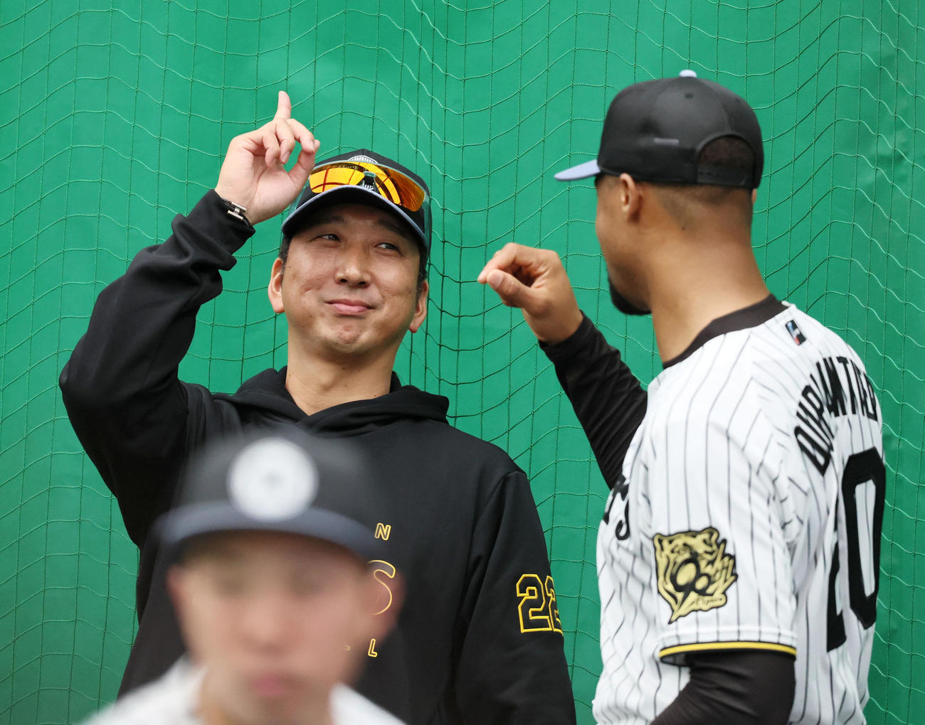 キャンプ初日、ブルペンで投球練習を終えたデュプランティエ(右）のポーズをマネて指を上げる藤川監督（撮影・加藤哉）