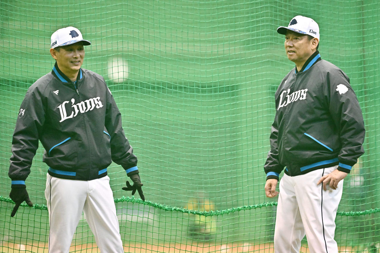 練習する選手を見守る西武西口監督（左）と鳥越ヘッドコーチ（撮影・滝沢徹郎）