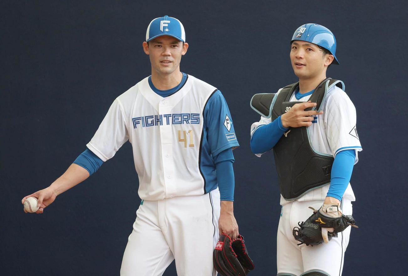 ブルペンで投球後、捕手を務めた郡司（右）と話す日本ハム福谷（撮影・黒川智章）