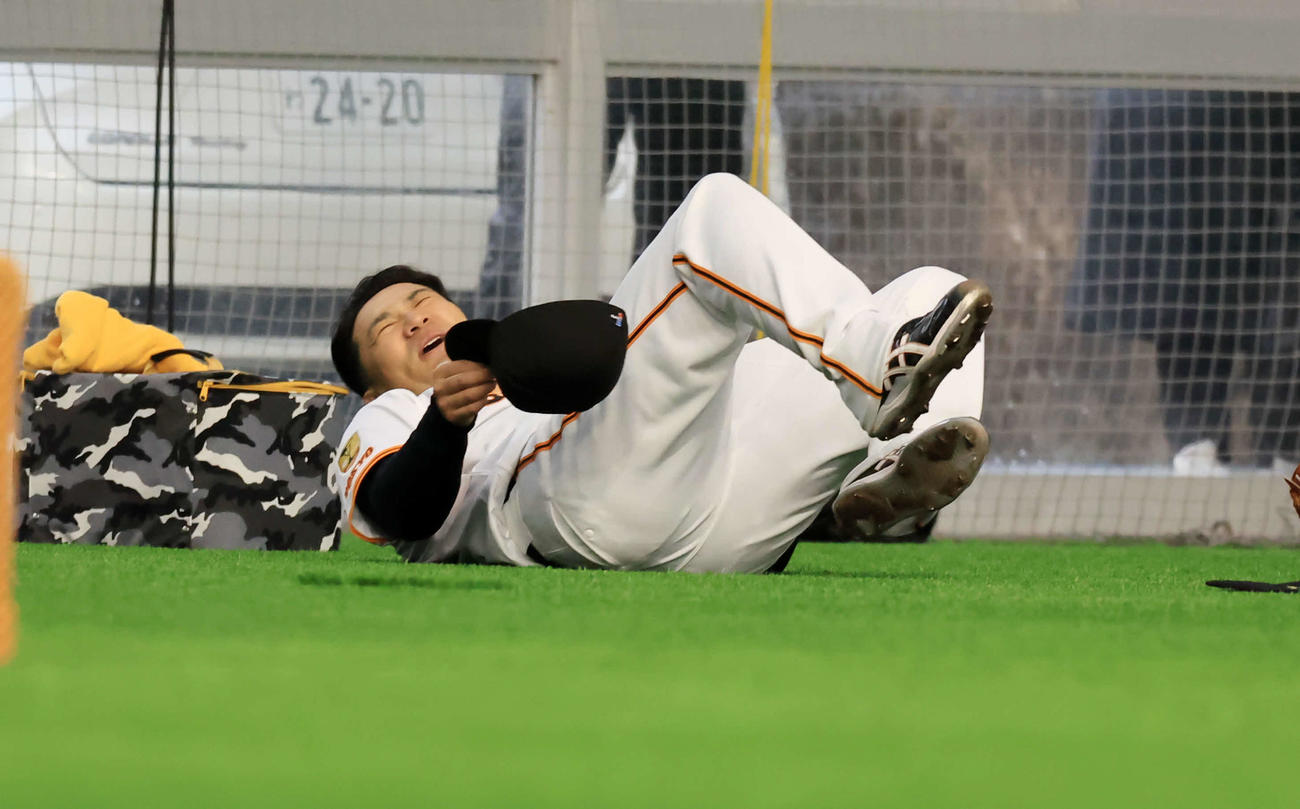 キャンプ初日、巨人久保巡回投手コーチからのマンツーマン指導を終え、倒れ込む田中将（撮影・浅見桂子）