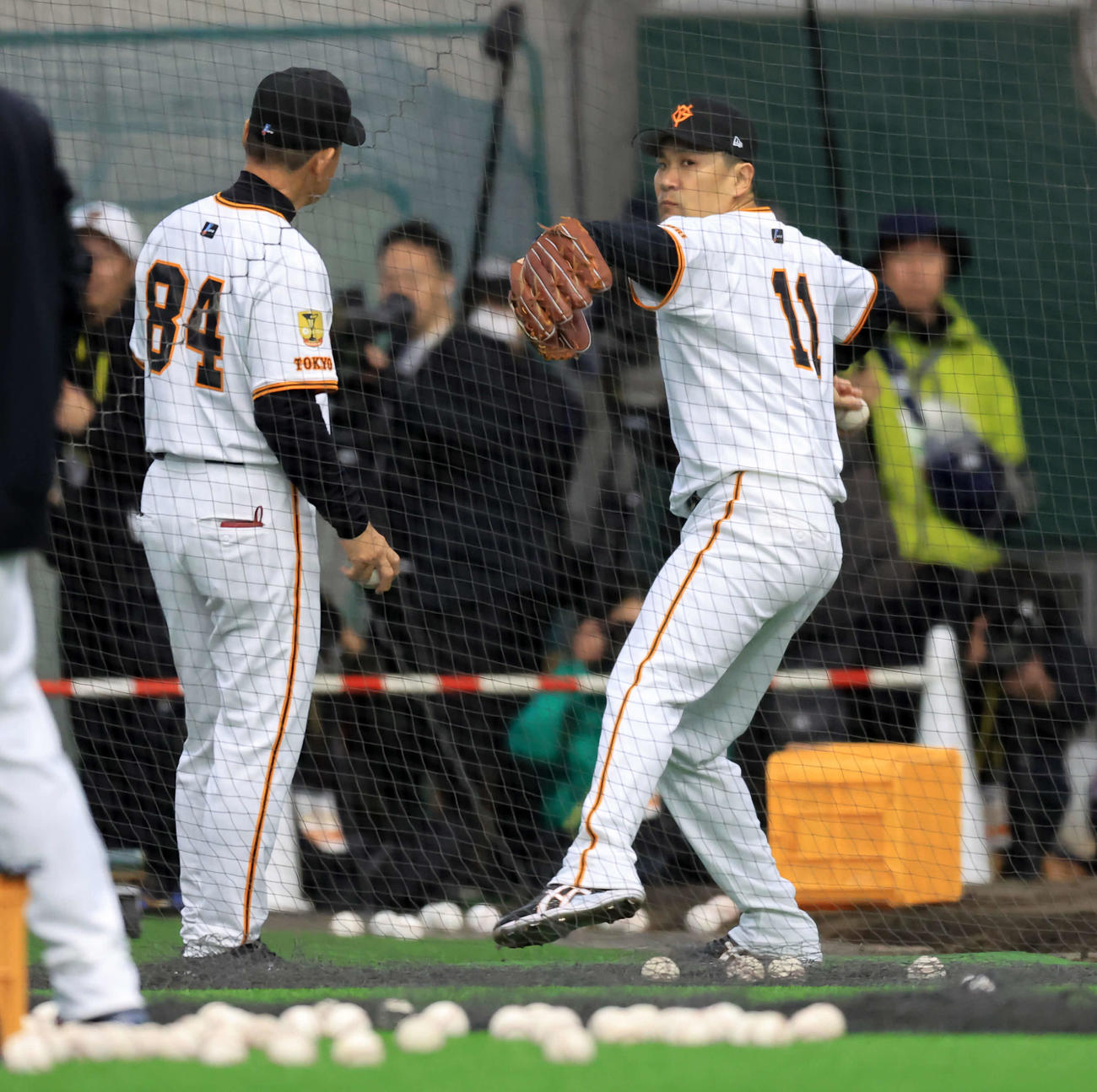 キャンプ初日、ブルペン横で巨人久保巡回投手コーチ（手前）から投球フォームの指導を受ける田中将（撮影・浅見桂子）