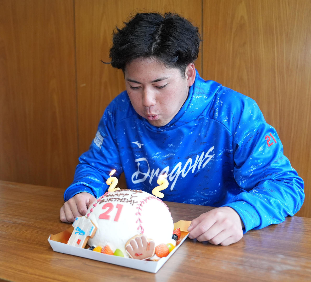 練習後、報道陣からプレゼントされたバースデーケーキのろうそくの火を消す今日誕生日の金丸（撮影・森本幸一）