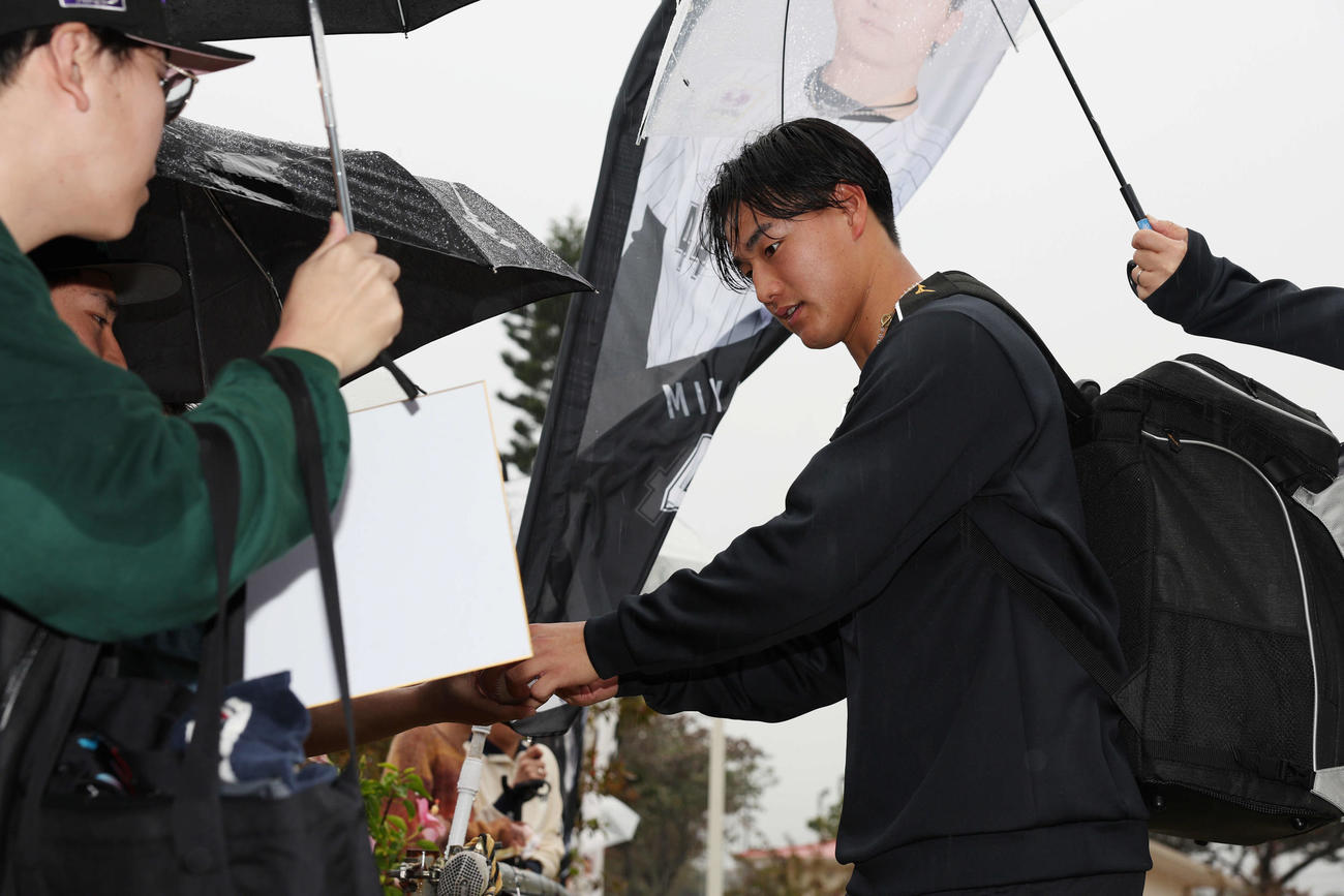 雨が降る中ファンにサインをするロッテ西川（撮影・宮地輝）