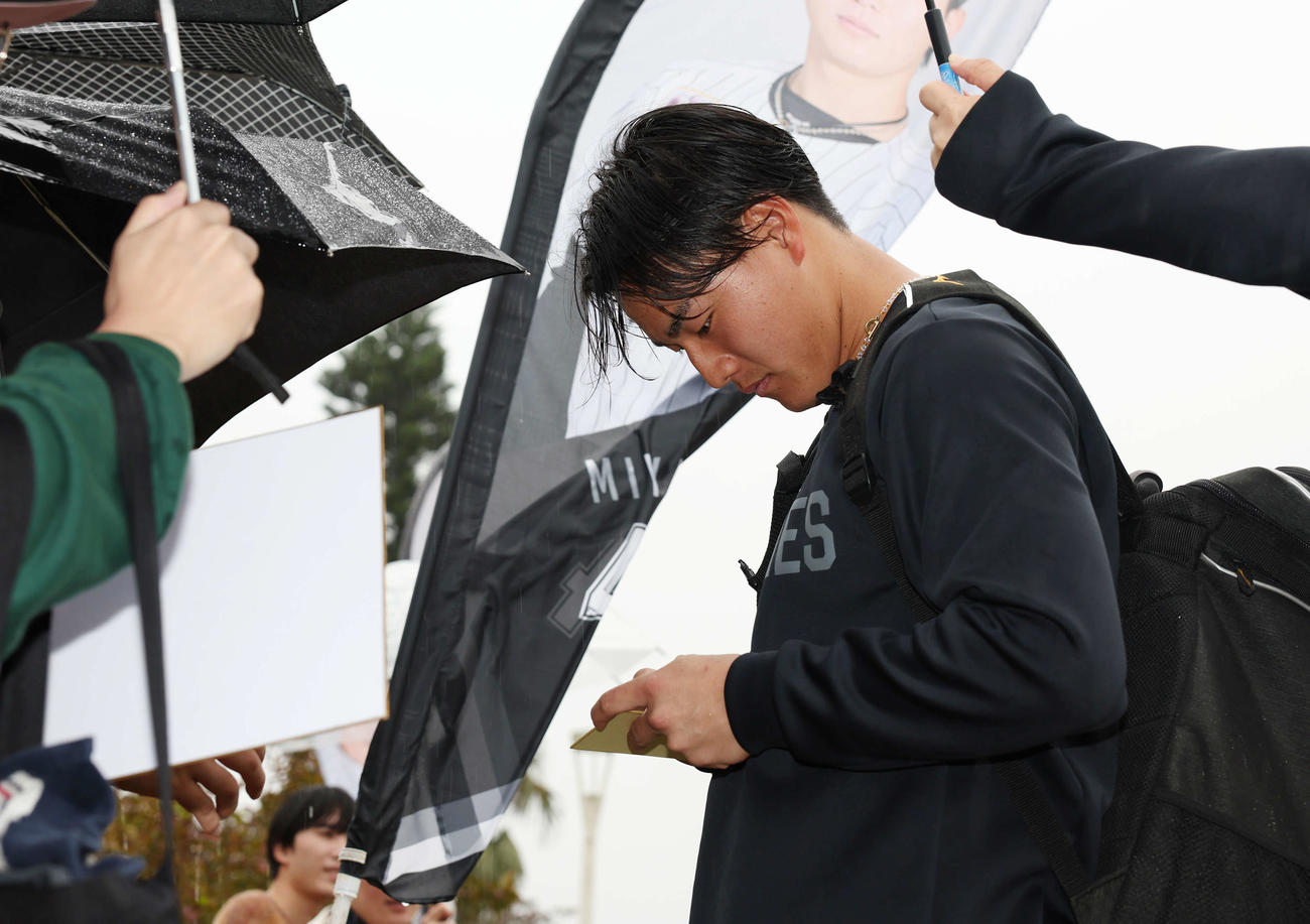 雨が降る中ファンにサインをするロッテ西川（撮影・宮地輝）