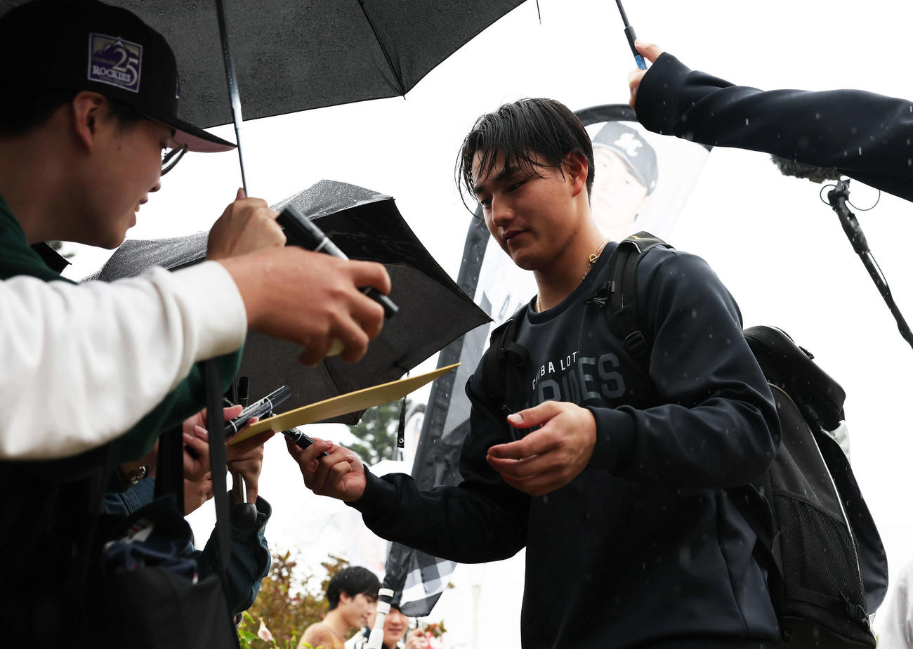 雨が降る中ファンにサインをするロッテ西川（撮影・宮地輝）