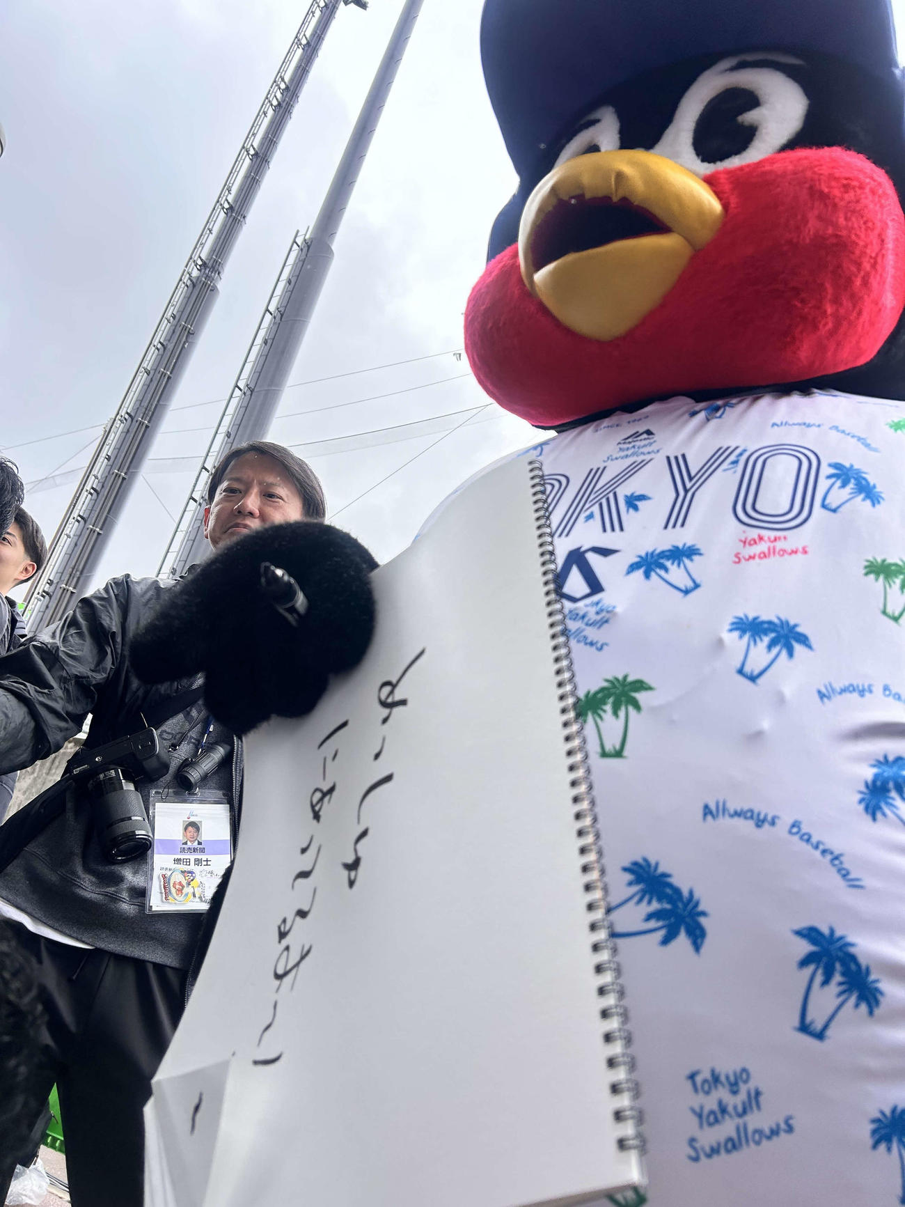 「めっちゅにあってるよ～！」のフリップを持ち、ヤクルト山田の取材に乱入したつば九郎（撮影・上田悠太）