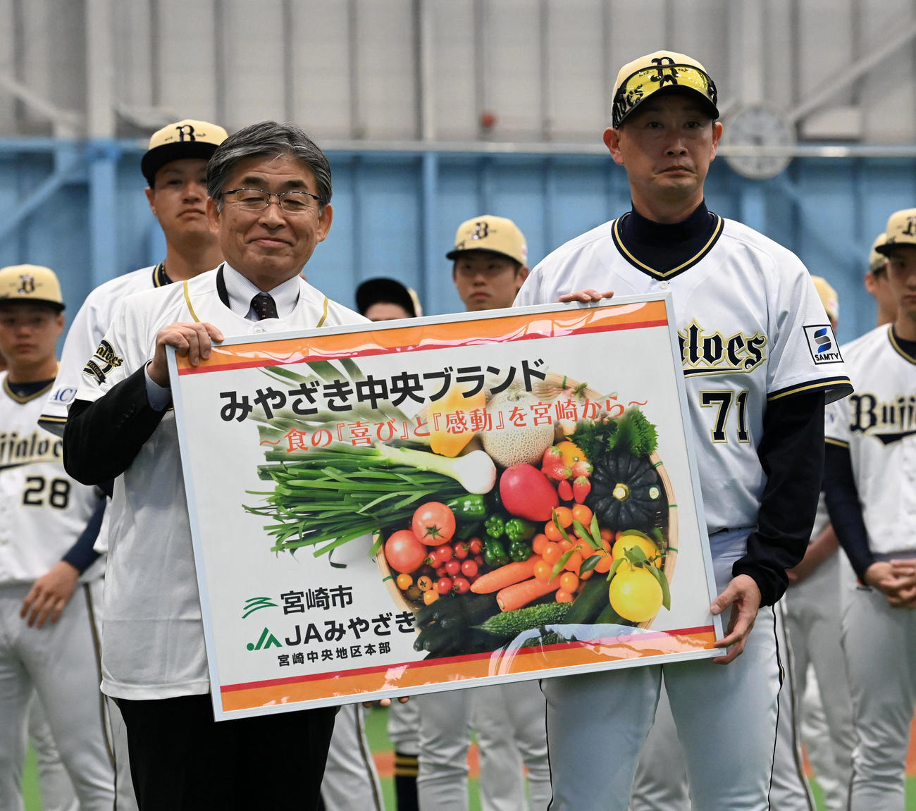 宮崎市の野菜を贈呈され、代表して受け取ったオリックス岸田監督。左は宮崎市の永山副市長（撮影・前岡正明）