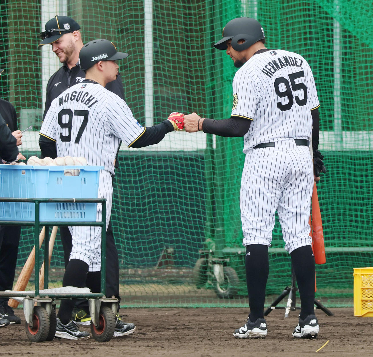 キャンプ初日、ランチ特打を終え野口(左）とタッチするヘルナンデス（撮影・加藤哉）