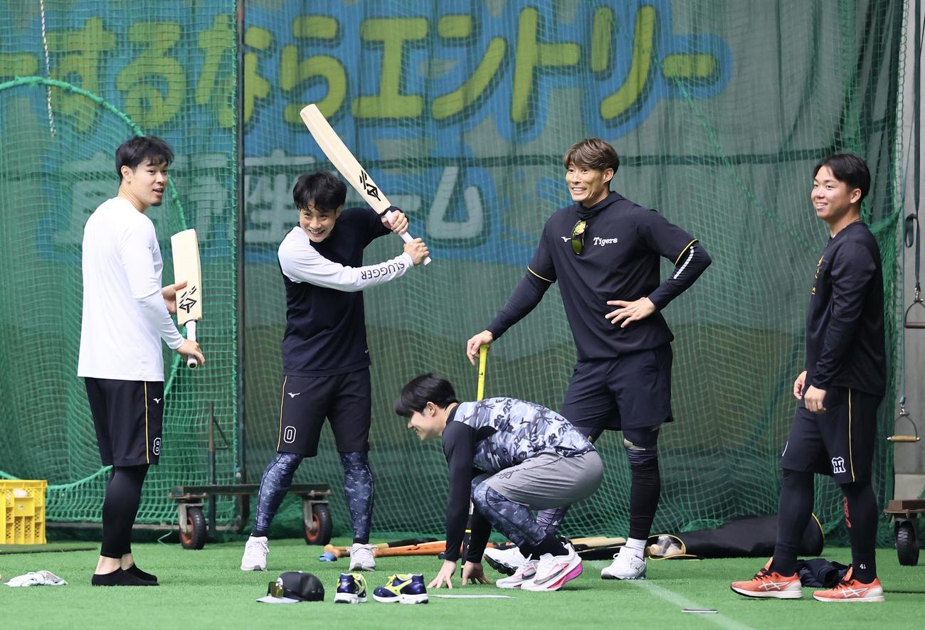 糸井臨時コーチ（右から2人目）に渡されたクリケット型のバットを手にする左から佐藤、木浪（撮影・藤尾明華）