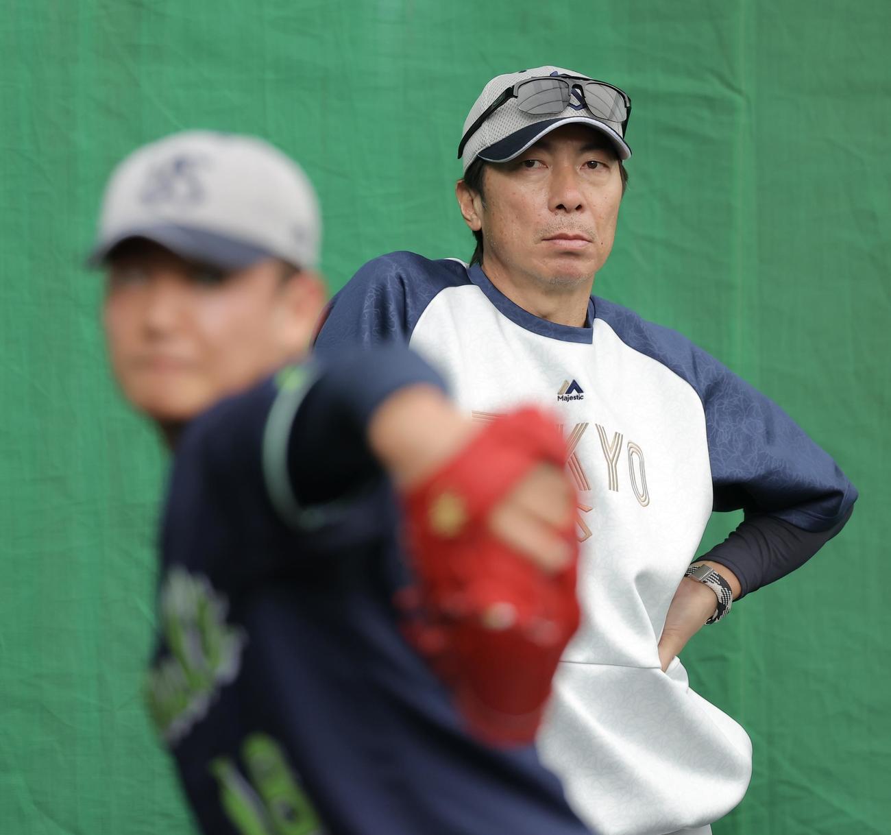 ブルペン投球するヤクルト奥川（手前）を見守る高津監督（撮影・河田真司）