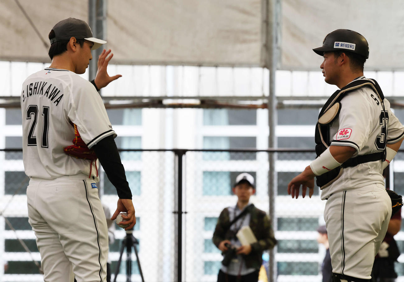 ブルペンで投球を終えロッテ佐藤（右）と言葉を交わす石川柊（撮影・宮地輝）