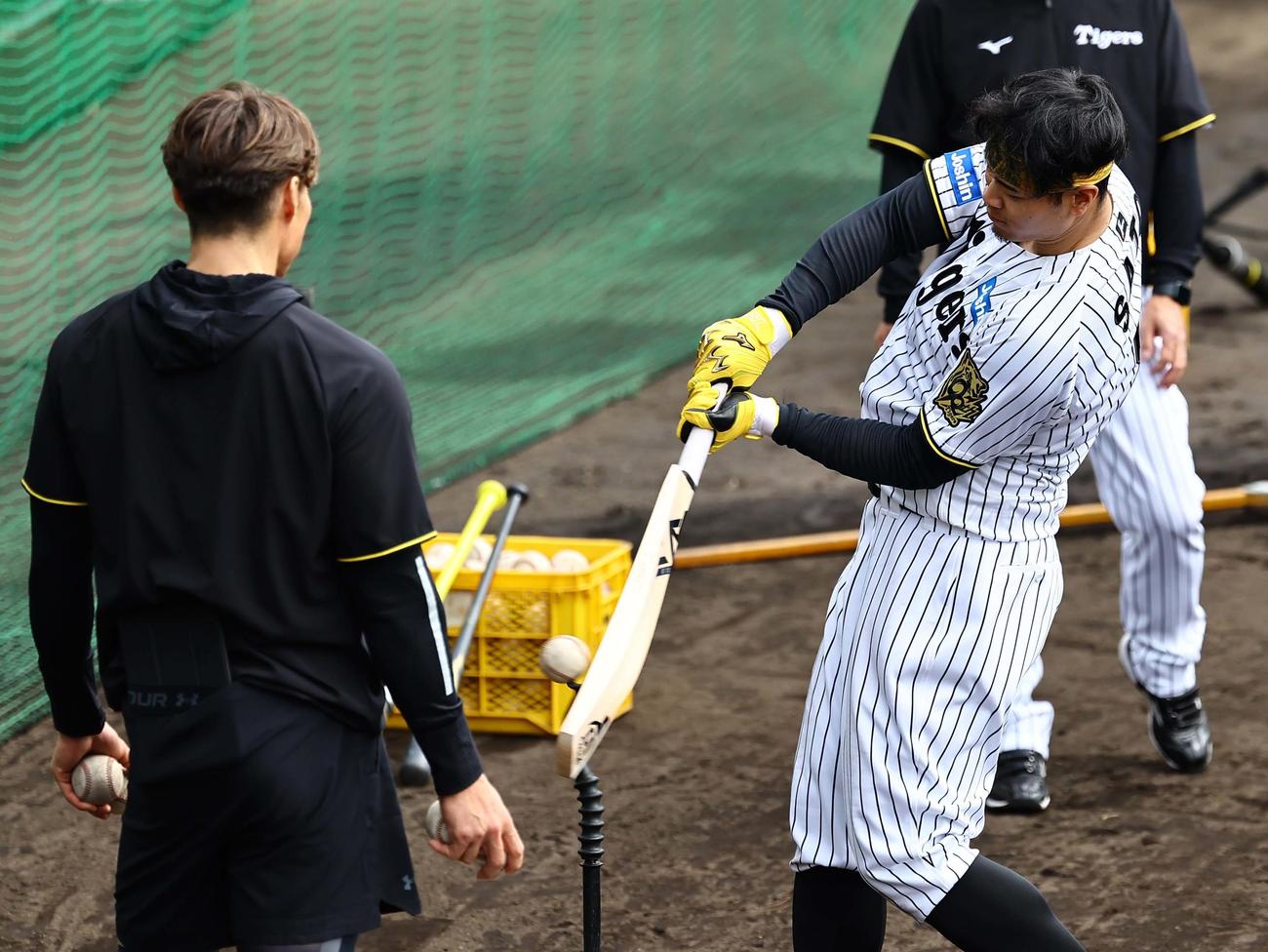 糸井臨時コーチ（左）の指導を受けた佐藤輝はクリケットバットで打撃練習をする（撮影・上田博志）