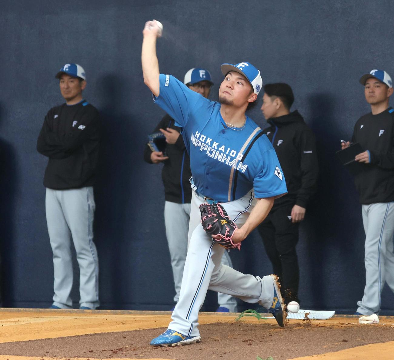ブルペンで投球する日本ハム伊藤。後方左は加藤投手コーチ（撮影・黒川智章）