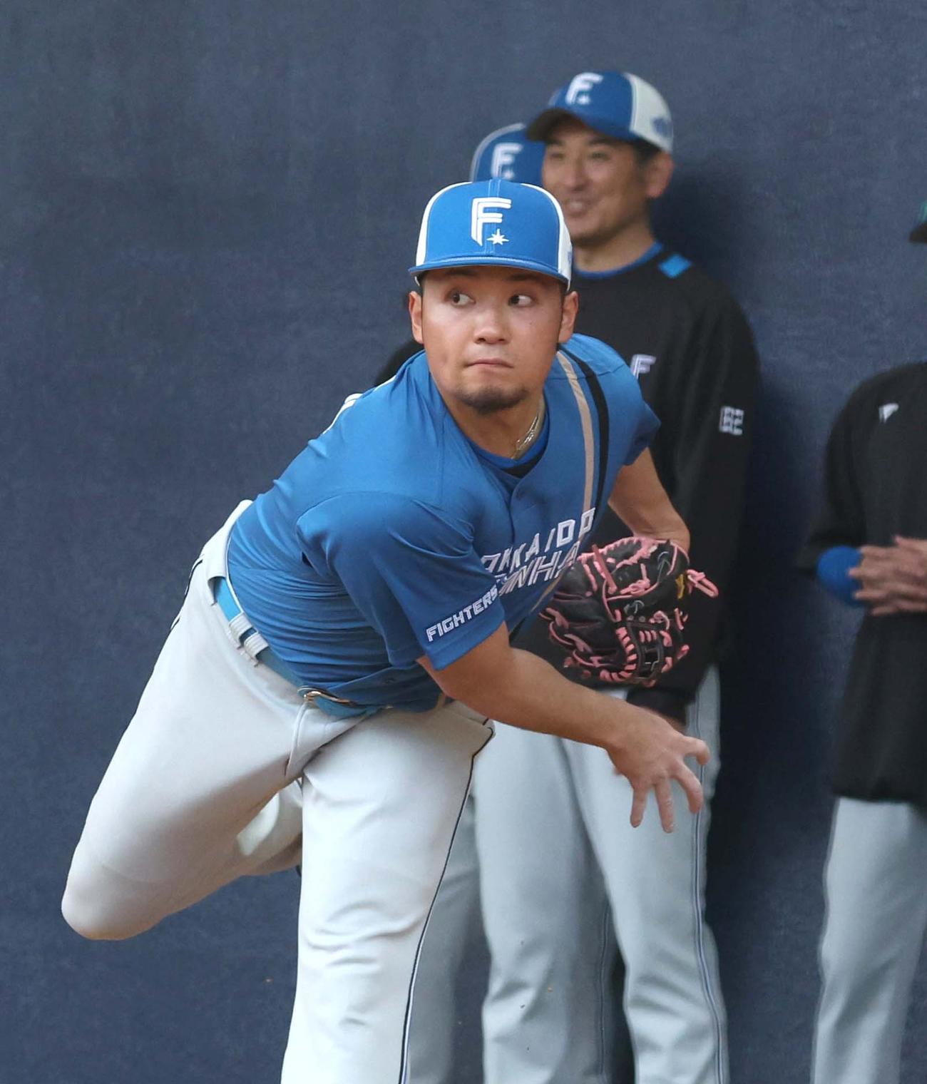 ブルペンで投球する日本ハム伊藤。後方は加藤投手コーチ（撮影・黒川智章）