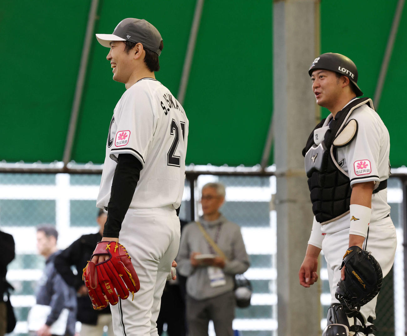 ブルペンでの投球を終えロッテ佐藤（右）と笑顔で話す石川柊（撮影・宮地輝）