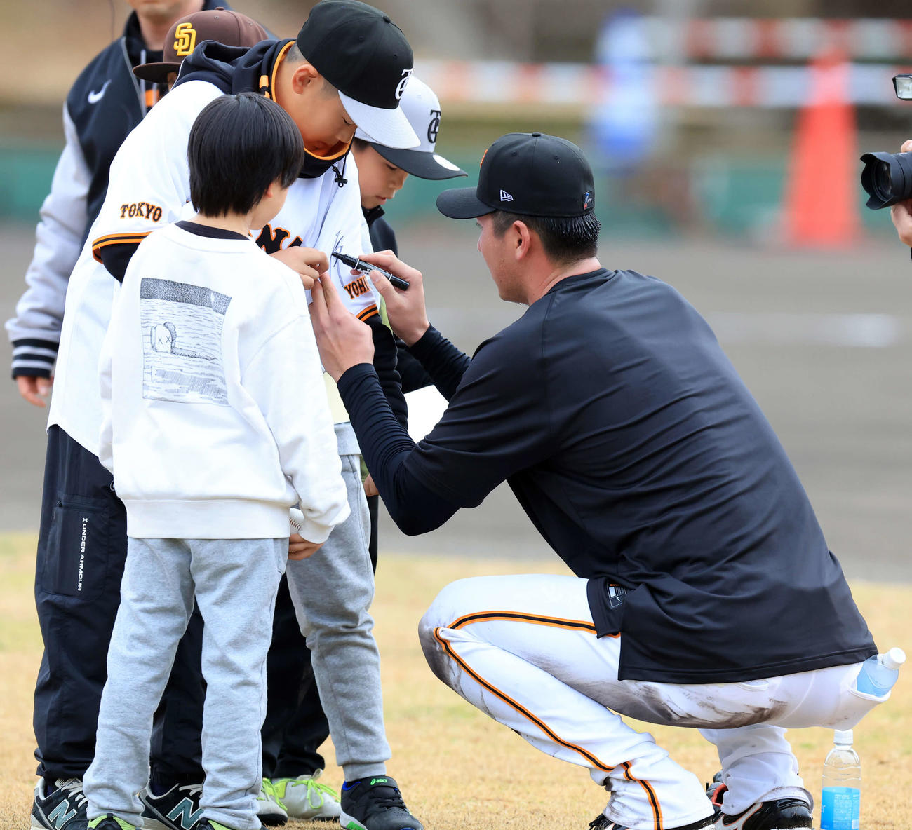 キャンプ2日目、少年ファンにサインする巨人秋広（撮影・浅見桂子）