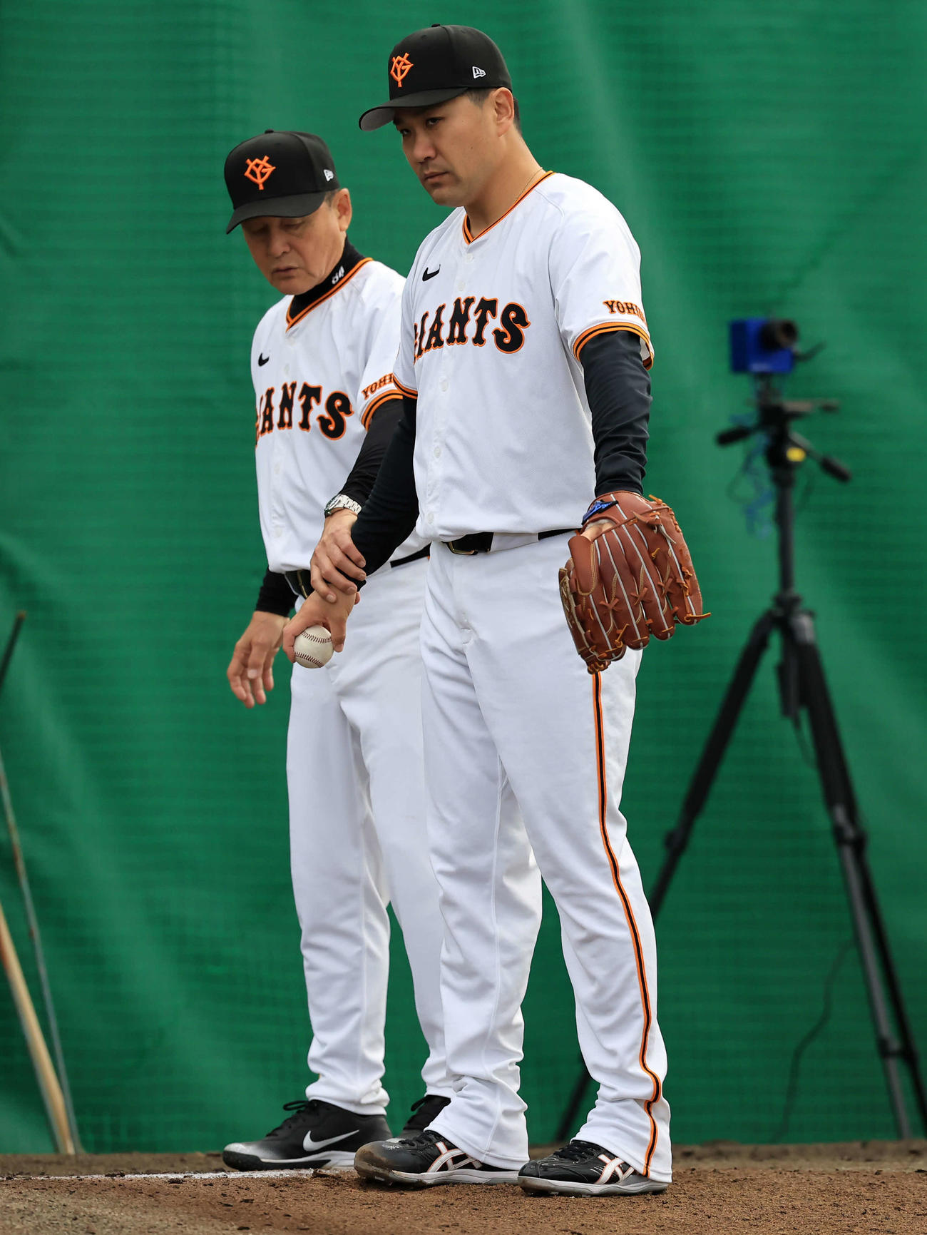 キャンプ2日目、ブルペンで巨人久保巡回投手コー（奥）から指導を受ける田中将（撮影・浅見桂子）