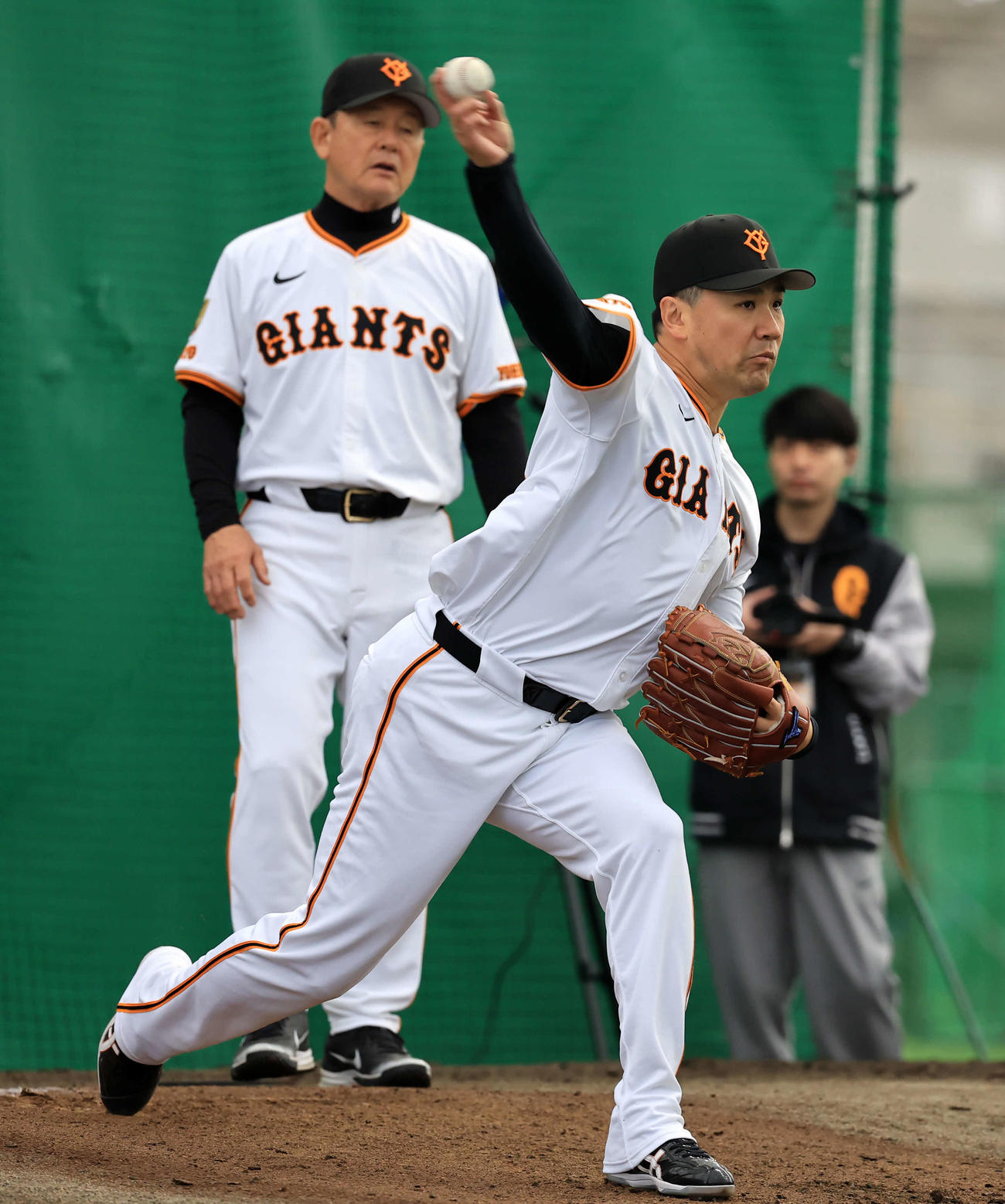 キャンプ2日目、ブルペンで巨人久保巡回投手コー（奥）から指導を受け投げ込む田中将（撮影・浅見桂子）