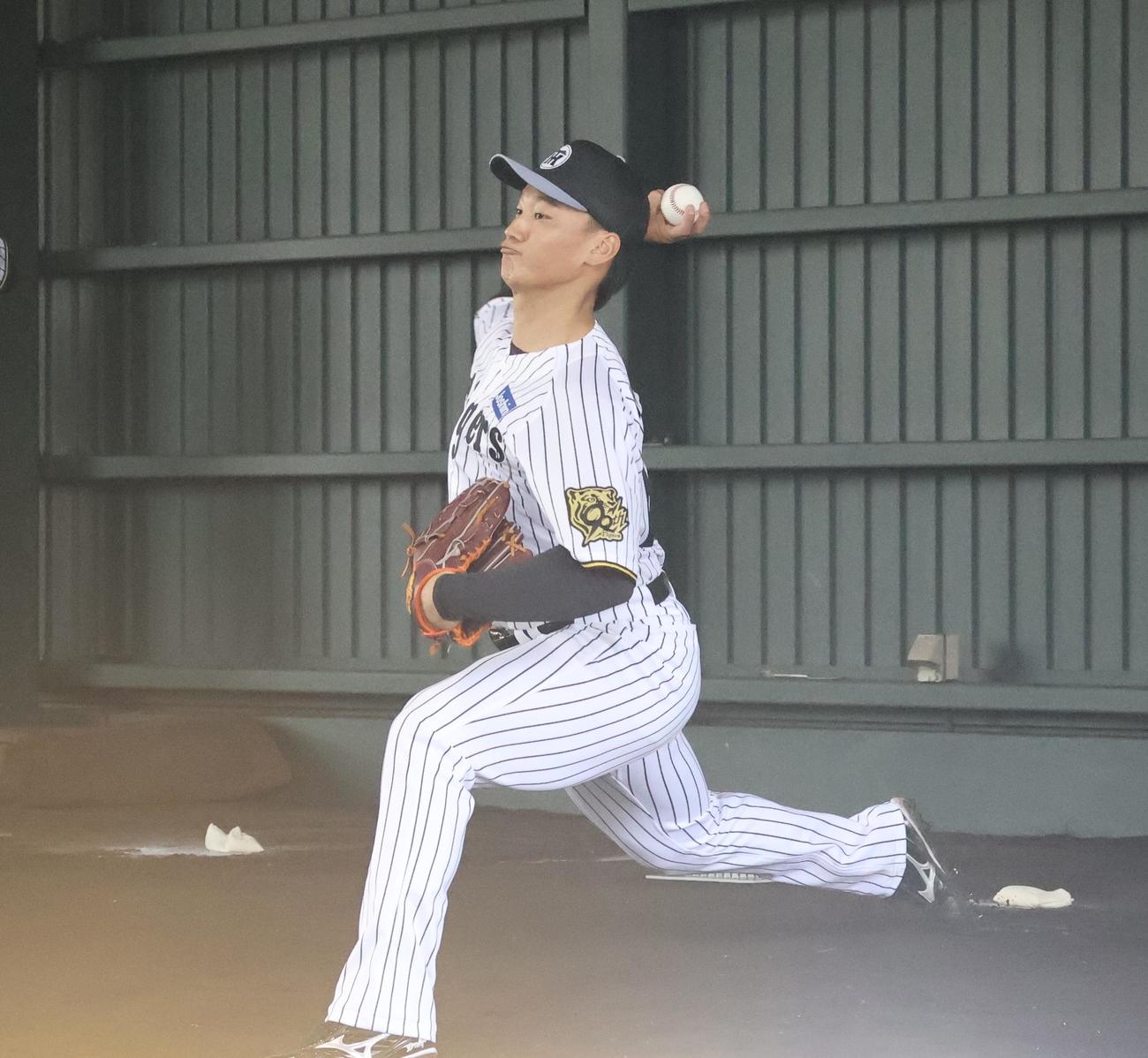 具志川キャンプのブルペンで阪神嶋村に向けて投球を行う森木（撮影・塚本光）