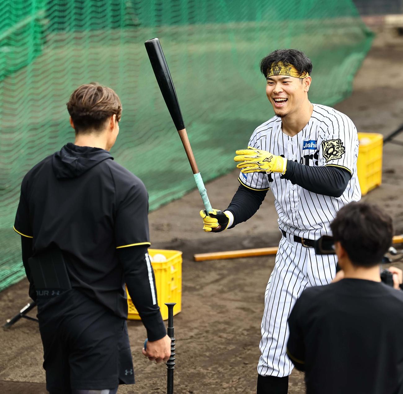 臨時コーチの糸井氏（左）の指導を笑顔で受ける佐藤輝（撮影・上田博志）