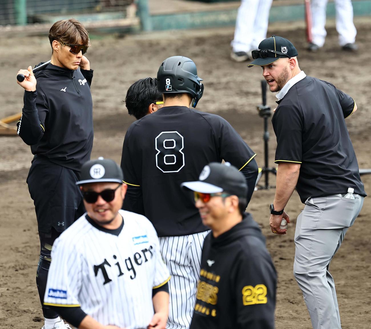 佐藤輝（中央）を指導するサンズ氏。右は糸井臨時コーチ、手前右は藤川監督、左は小谷野コーチ（撮影・上田博志）