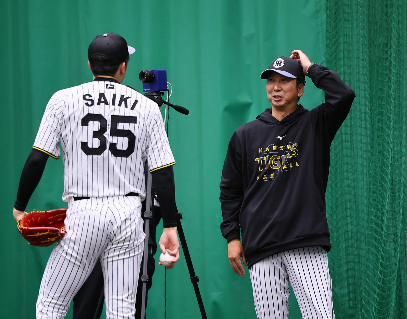 ブルペンで投球練習をする才木に声をかける藤川監督（撮影・藤尾明華）