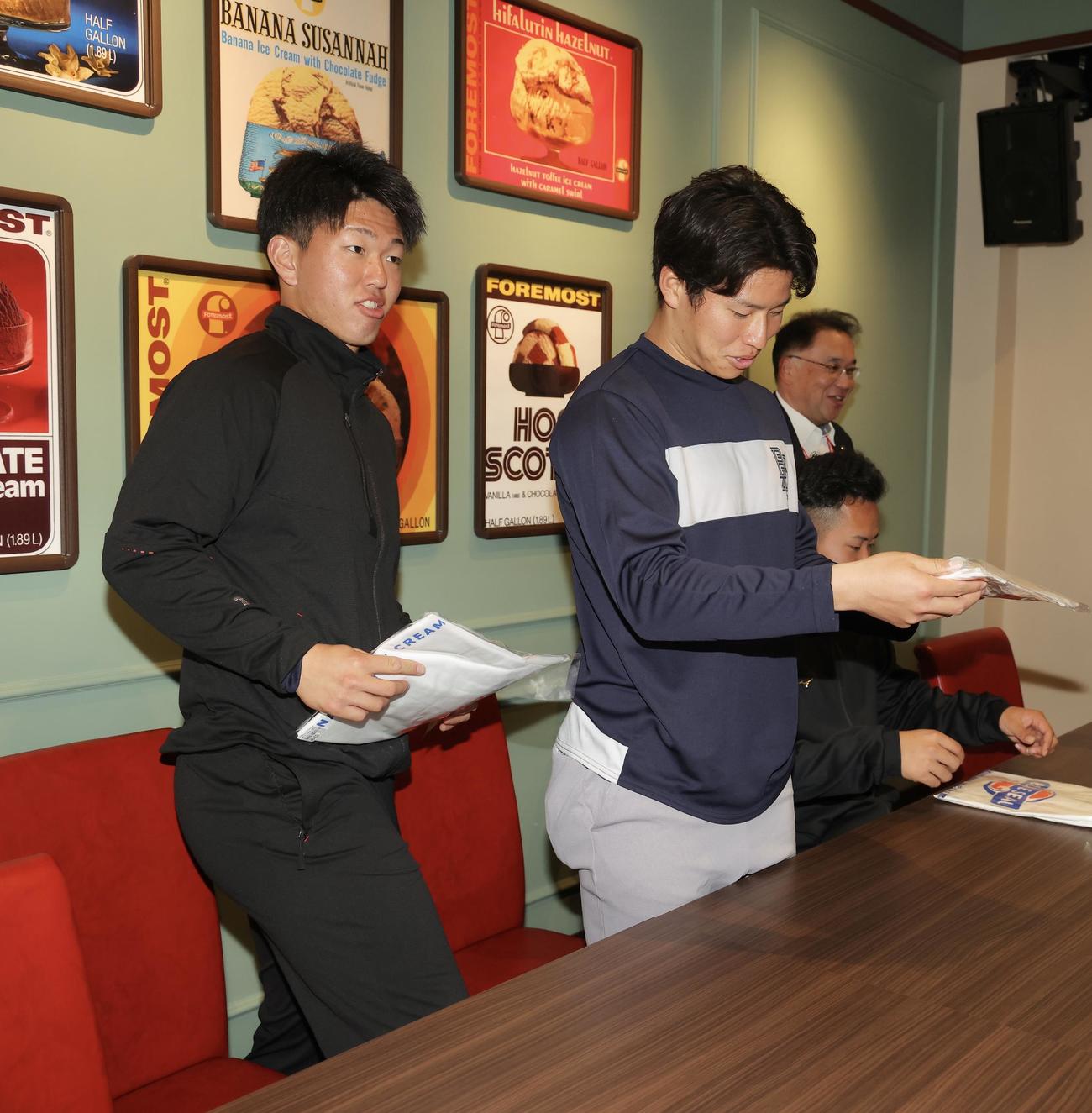フォーモストブルーシール株式会社村上代表取締役社長（奥）からブルーシールTシャツをプレゼントしてもらうヤクルトの新人選手たち。左から矢野、下川、荘司（撮影・河田真司）