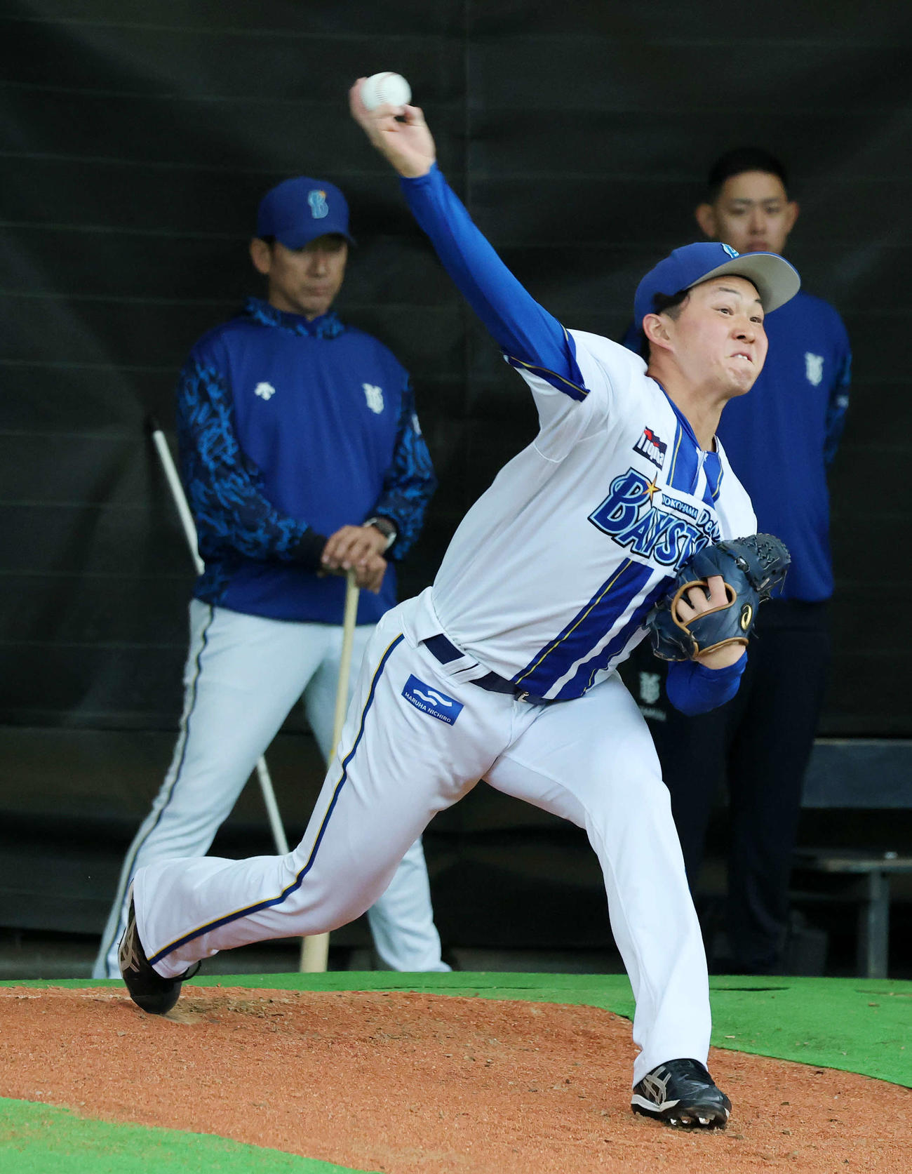 DeNA三浦監督（左）が見つめる中、ブルペンで投球練習する竹田（撮影・鈴木正人）